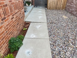 Raised the sidewalk to corrected height and slope, eliminating tripping hazards.